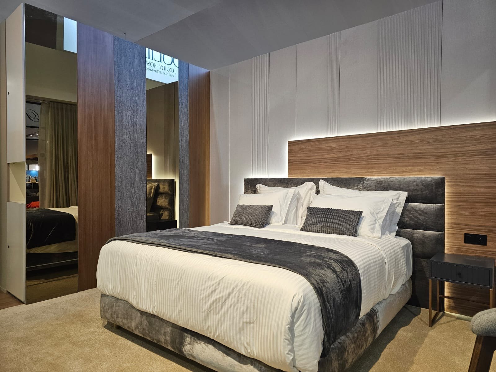 Suite parentale mise en scène sur le stand Dolidol Luxury Hospitality avec boiseries et éclairage indirect