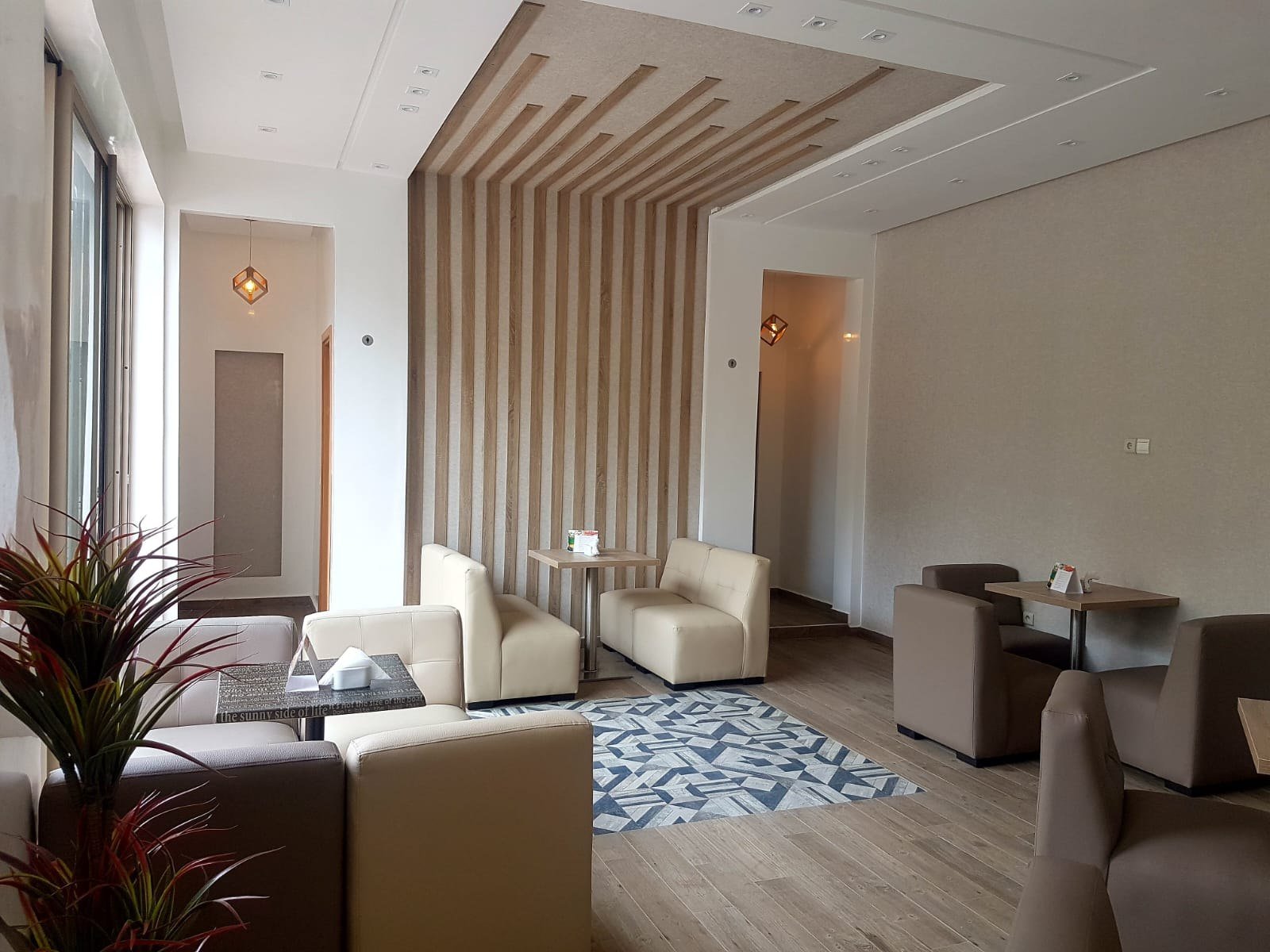 Lounge professionnel aménagé avec assises contemporaines et claustra en bois