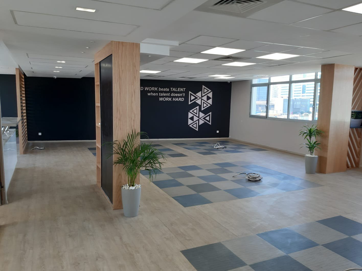 Plateau de bureaux collaboratif avec mobilier blanc, bois et cloisons