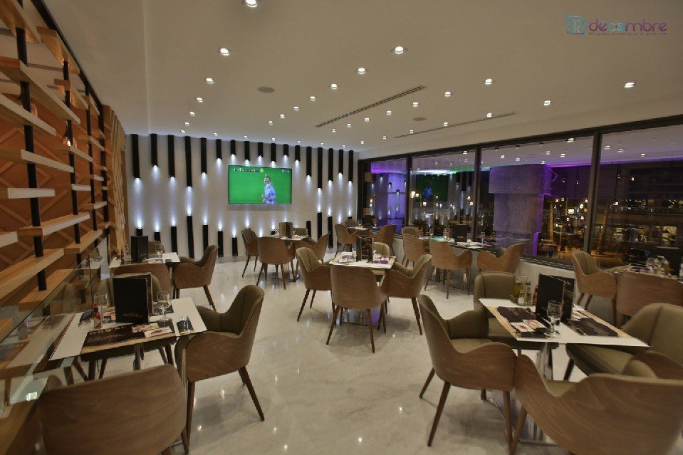 Salle de restaurant contemporaine avec éclairage chaud et mobilier en bois
