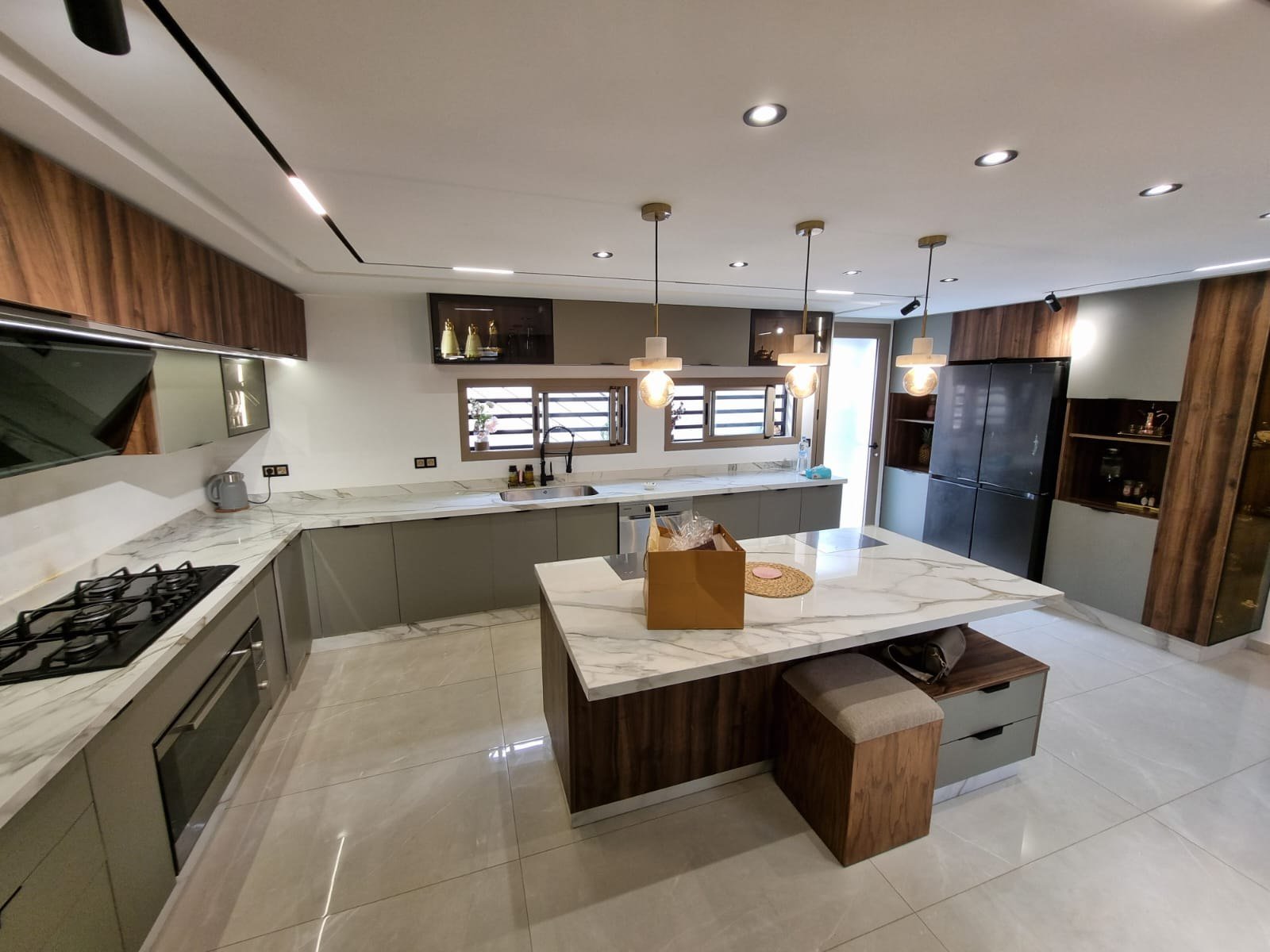 Cuisine sur mesure avec îlot central, façades bois et plan de travail clair